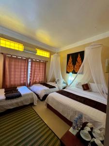 a hotel room with two beds and a table at Shining Angkor Boutique Hotel in Siem Reap