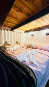 a large bed in a bedroom with a wooden ceiling at Tiny Urubici -P Cachoeira da Neve in Urubici