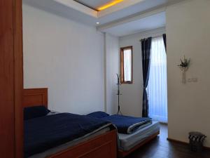 a bedroom with a bed and a window at Teras Senja Sikunir in Kejajar +2 photos