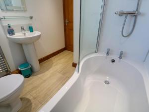 a bathroom with a tub and a toilet and a sink at The Baler House in Hayle +25 photos
