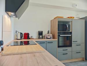 una cucina con piano di lavoro, forno a microonde e piano cottura di La Maison des Falaises a Crozon