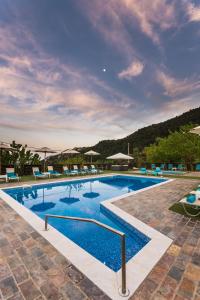 a large swimming pool with blue lounge chairs in a resort at Ilaeira Mountain Resort in Toriza
