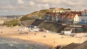 a beach with a group of people on the sand at Grande maison familiale à deux pas de la mer in Le Portel