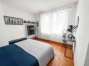 a bedroom with a blue and white bed and a fireplace at Grande maison familiale à deux pas de la mer in Le Portel