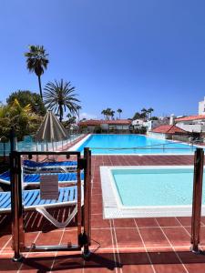 a view of a swimming pool from a balcony with two chairs at CAN HOST YUMBO - Private Terrace AA in San Bartolomé