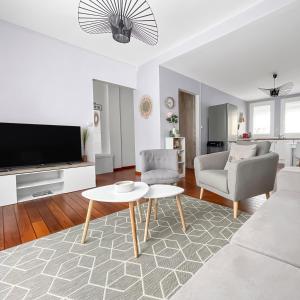 a living room with a couch and a tv and a table at Grande maison familiale à deux pas de la mer in Le Portel