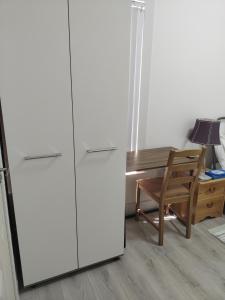 Un refrigerador blanco al lado de un escritorio y una silla. en Bet El Cozy & Comfy Room 4, en Parkside