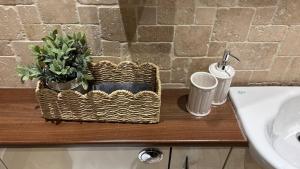 a bathroom counter with a sink and a basket with a plant at Roserin Coorie, Perth - just a few minutes walk from the city centre! in Perth +16 photos