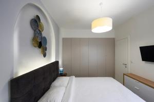 A bed or beds in a room at Blu & Marrone Suites-parking included