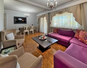 a living room with a purple couch and a table at SkyView Paralia in Paralia Katerinis