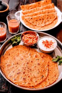 Kesar Heritage Boutique Home Stay في جودبور: ثلاثة أطباق من خبز النان على الطاولة