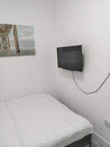 Un dormitorio con una cama y un televisor en una pared. en Bet El Cozy & Comfy Room 4, en Parkside