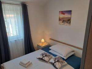 a bedroom with a bed with two towels on it at Apartmani Mila-Casa Bianca in Medulin