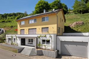 una grande casa gialla con garage di Ferienwohnung Rebenrain, 80qm a Steinach