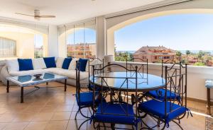 un salon avec un canapé, une table et des chaises dans l'établissement Fantástico Ático Dúplex en Marbella, con vistas al mar y a 300 metros de la playa, à Marbella