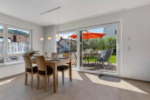 una sala da pranzo con tavolo, sedie e ombrellone di Ferienwohnung Rebenrain, 80qm a Steinach