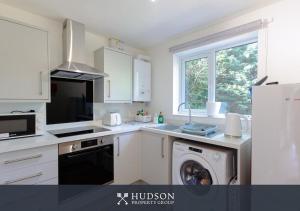 a white kitchen with a washer and a dishwasher at 1-Bedroom Apartment with Parking in Wellington