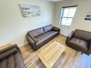 a living room with a couch and two chairs at Jolly Roger Cottage - Part of the The Bay Filey Holiday Village with pool, gym and direct beach access, pub, restaurant, tennis and meadows walks in Filey
