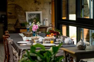 a dining room table with a blue table cloth and flowers at La Ferme des Andes in Quins