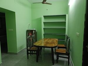 a dining room with a table and chairs and shelves at La Rasamb sejour villa in Kottakupam +10 photos