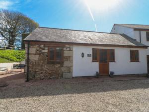 a small white house with a wooden door at The Coach House in Hayle