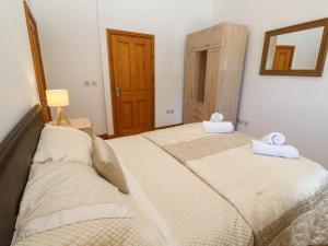 a bedroom with two beds with towels on them at The Coach House in Hayle