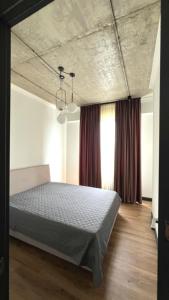 トビリシにあるApartment with big balcony at Didi Dighomiのコンクリートの天井のベッドのある寝室 +5枚の写真