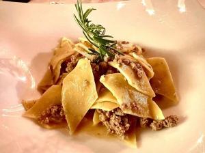 a white plate of food with pasta and a garnishment at Castello Di Petroia Dimora d'Epoca in Gubbio