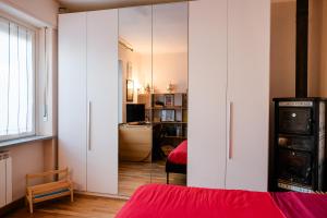 a bedroom with white cabinets and a red bed at La Cinciallegra in Val Della Torre