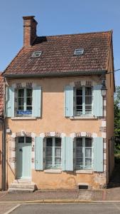 stary dom z niebieskimi okiennicami na budynku w obiekcie La Maison d'à Côté w mieście Saint-Amand-en-Puisaye
