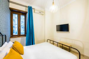 una camera da letto con due letti e una TV di Toledo Bright Apartment by Wonderful Italy a Napoli