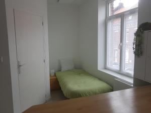 a small room with a bed in a window at 1A studio à neuf Tout équipé in Tourcoing