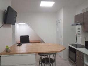 a kitchen with a wooden table and two chairs at 1A studio à neuf Tout équipé in Tourcoing