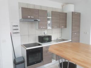 a small kitchen with a table and a microwave at 1A studio à neuf Tout équipé in Tourcoing +8 photos