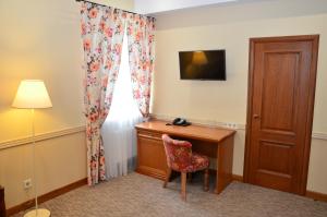 a hotel room with a desk and a window at Premier Hotel Pochaiv in Pochayiv