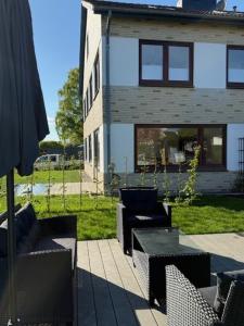 a patio with two chairs and a table in front of a house at Ostseeliebe 5 in Dahme