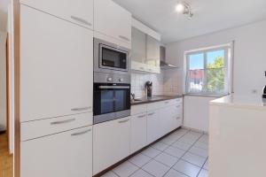 a white kitchen with white appliances and a window at Casa di Napolitano 3 in Radolfzell am Bodensee