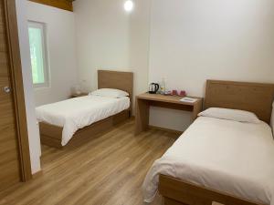 a room with two beds and a desk and a window at Rifugio Pian dei Ciclamini in Lusevera