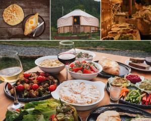 una tavola ricoperta di piatti di cibo e bicchieri di vino di Glamping Tago a Khulo