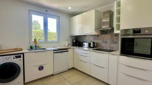 a kitchen with white cabinets and a window at Galo - Private Pool - 8 Guests - Albufeira in Albufeira