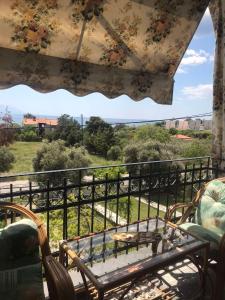 een balkon met een tafel en een trein in de verte bij ARIS House in Agia Paraskevi