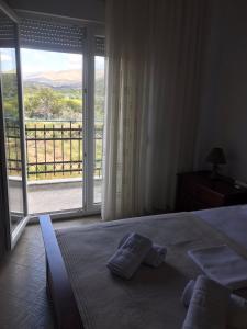 een slaapkamer met een bed en een groot raam bij ARIS House in Agia Paraskevi +45 foto's