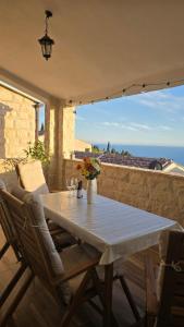 a table and chairs on a patio with a view of the ocean at Blue Horizon Rezevici in Katun