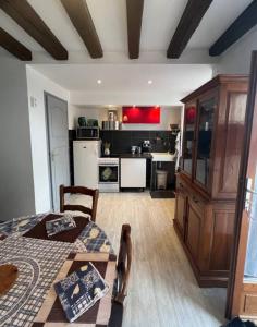 Dieses Zimmer verfügt über eine Küche mit einem Tisch und einem sidx sidx. in der Unterkunft Maison de village au pied de la montagne in Lumbin