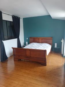 a bedroom with a bed and a blue wall at Belle maison familiale près de La Rochelle in Ferrières
