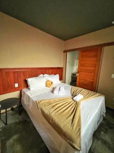 a hotel room with a large bed with white sheets at Kaha Mar - Patacho in Pôrto de Pedras