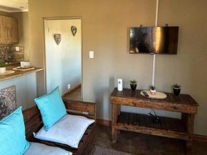 a living room with blue pillows and a table at Farmers Lodge in Piet Retief