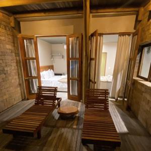 two benches in a room with a bedroom at Kaha Mar - Patacho in Pôrto de Pedras
