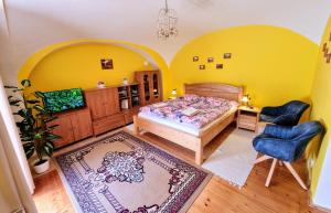 a bedroom with a bed and a desk and chairs at Historical house in the center Levoča with parking in Levoča