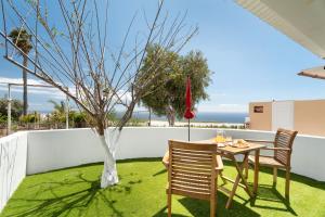 a table and two chairs and a tree on a patio at La Atalaya in Adeje